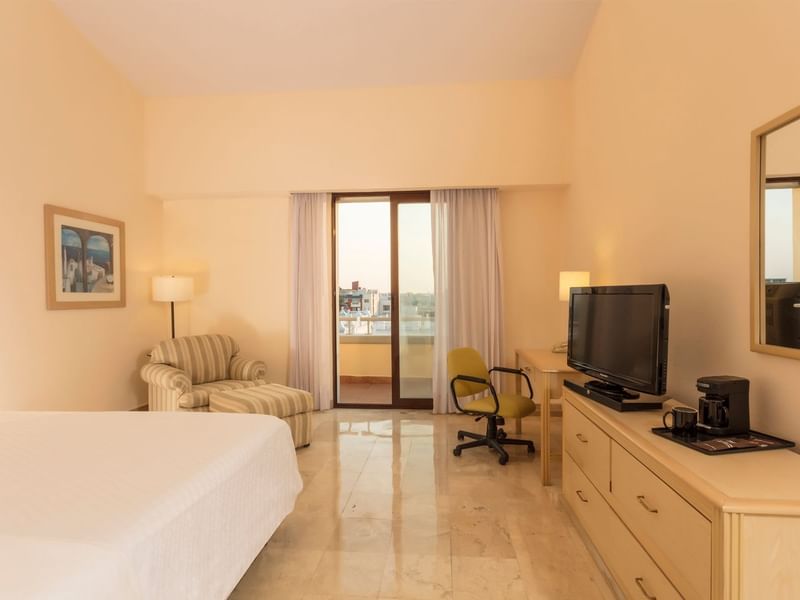 Executive Room with a comfortable chair, work desk, and a TV at Fiesta Inn