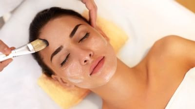 woman getting facial treatment with brush