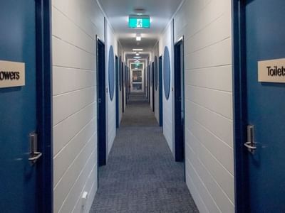 Hallway with blue doors labeled Showers and Toilets at La Trobe University - Orde House.