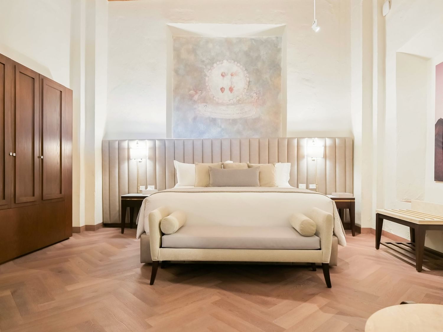 King Real room with bed, bench, and artwork at Quinta Real Puebla in Heroica Puebla de Zaragoza.