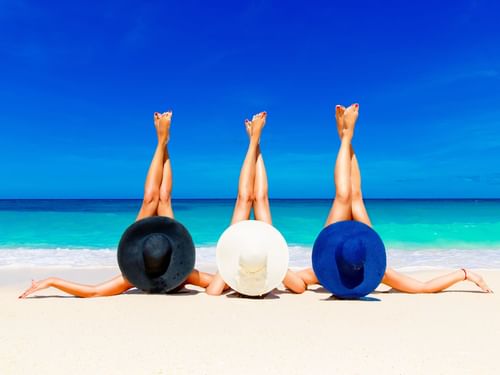 Three girls sunbathing on the beach at The Reef 28