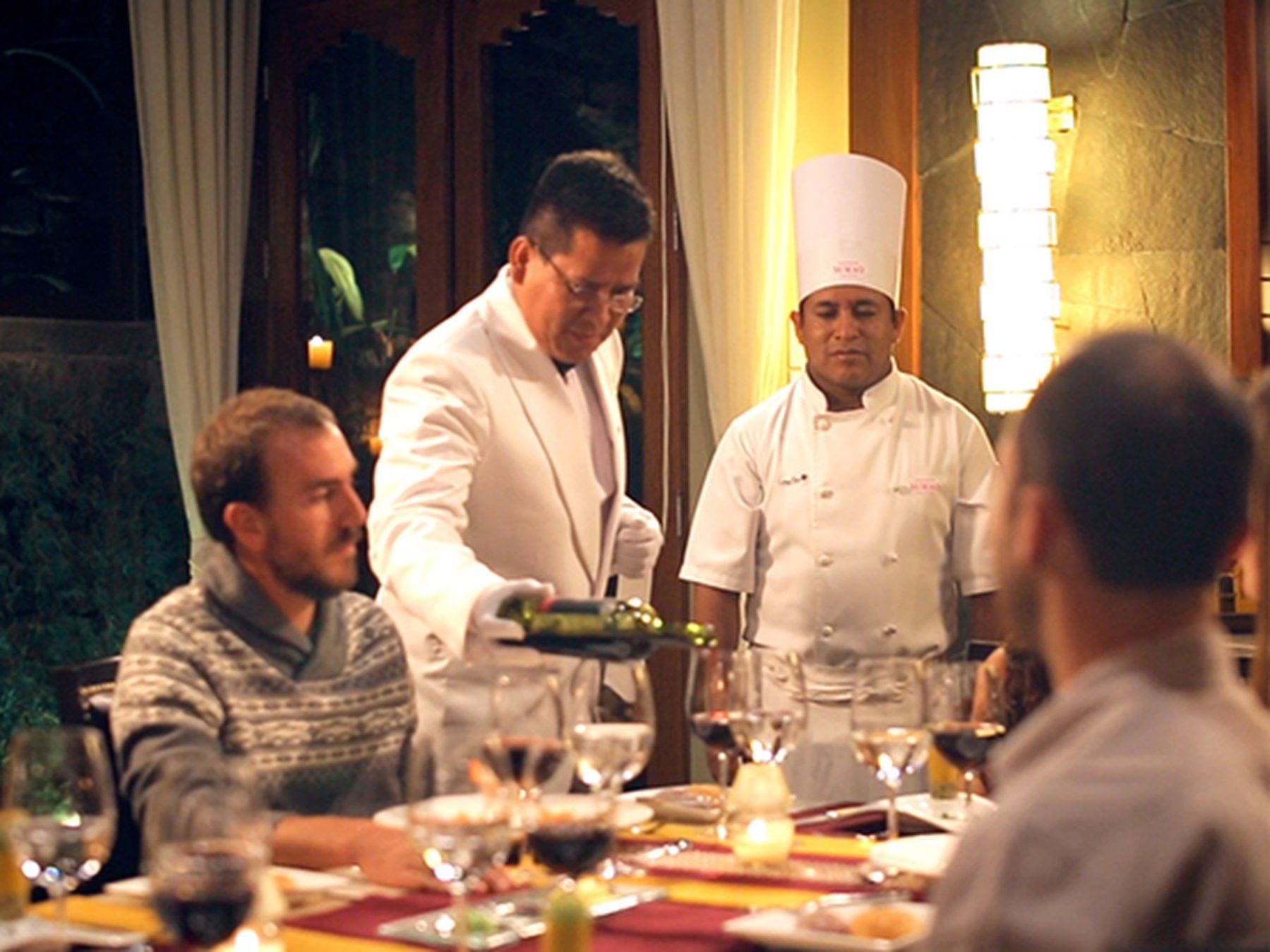 A waiter poring red wine in Private dining room at Hotel Sumaq