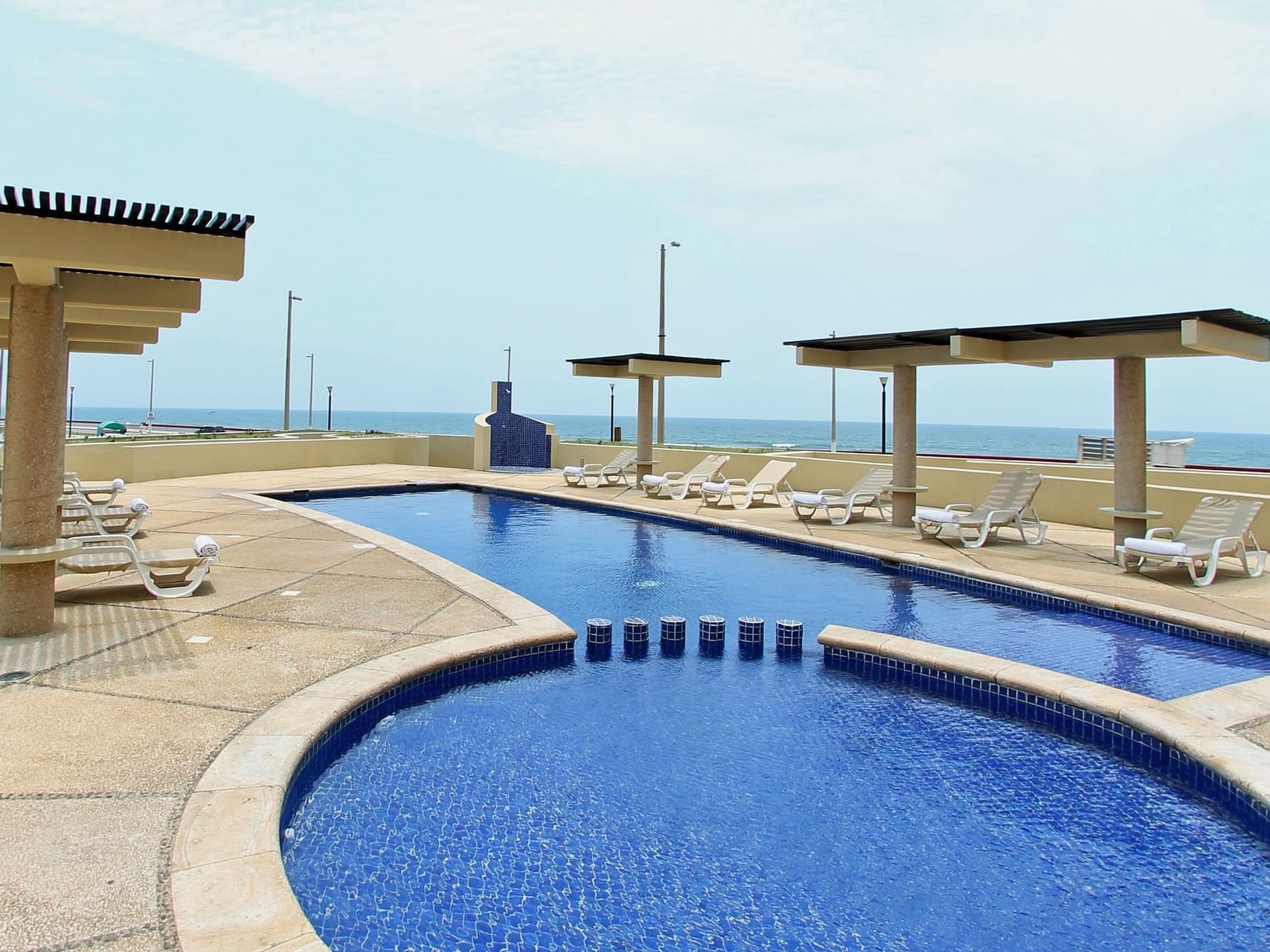 Outdoor swimming pool area with sunbeds at Fiesta Inn Hotels
