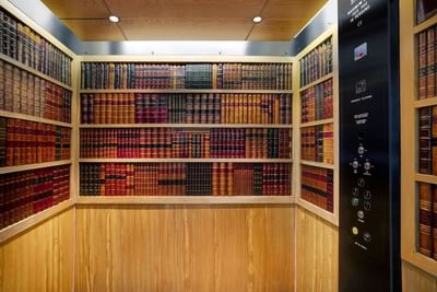 Lift interior with bookshelf wallpaper at Sloane Square Hotel