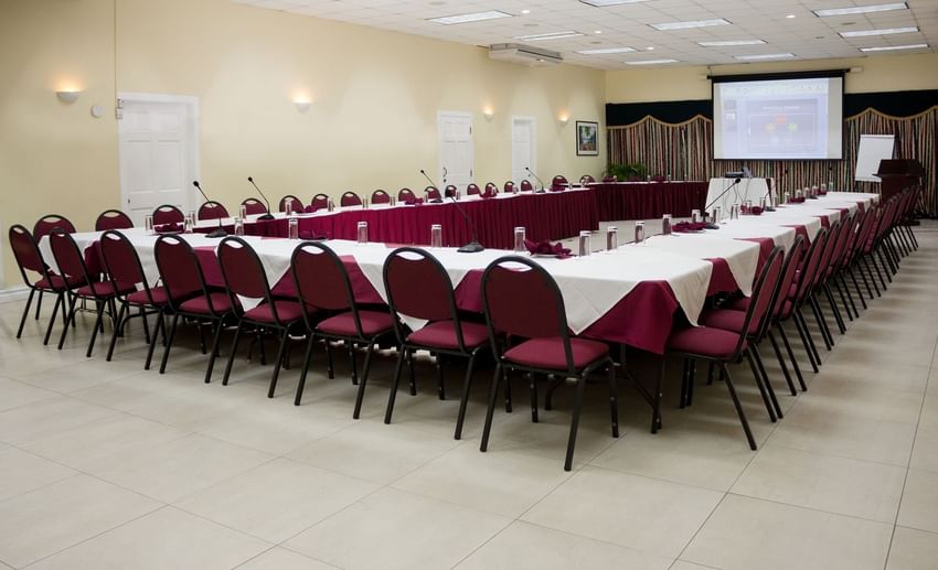 Modern Dolphins Conference Room with U-shaped table setup and projector at Bay Gardens Hotels and Resorts