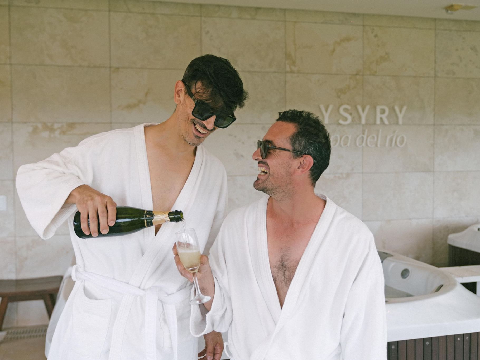 Two men enjoying champagne on bathrobes at Grand Hotels Lux