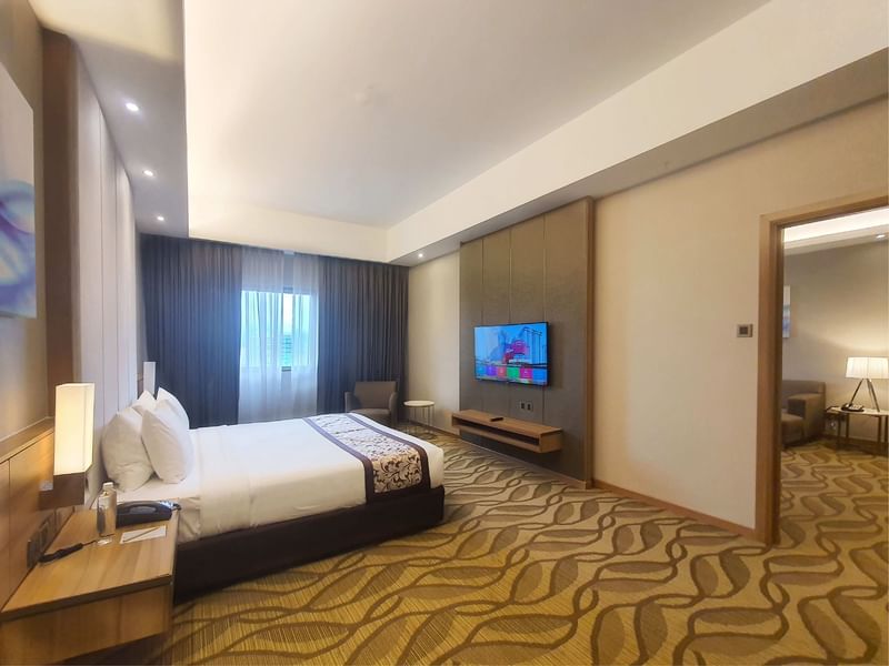 King-size bed with a single sofa in Suite at Sunway Hotel Seberang Jaya