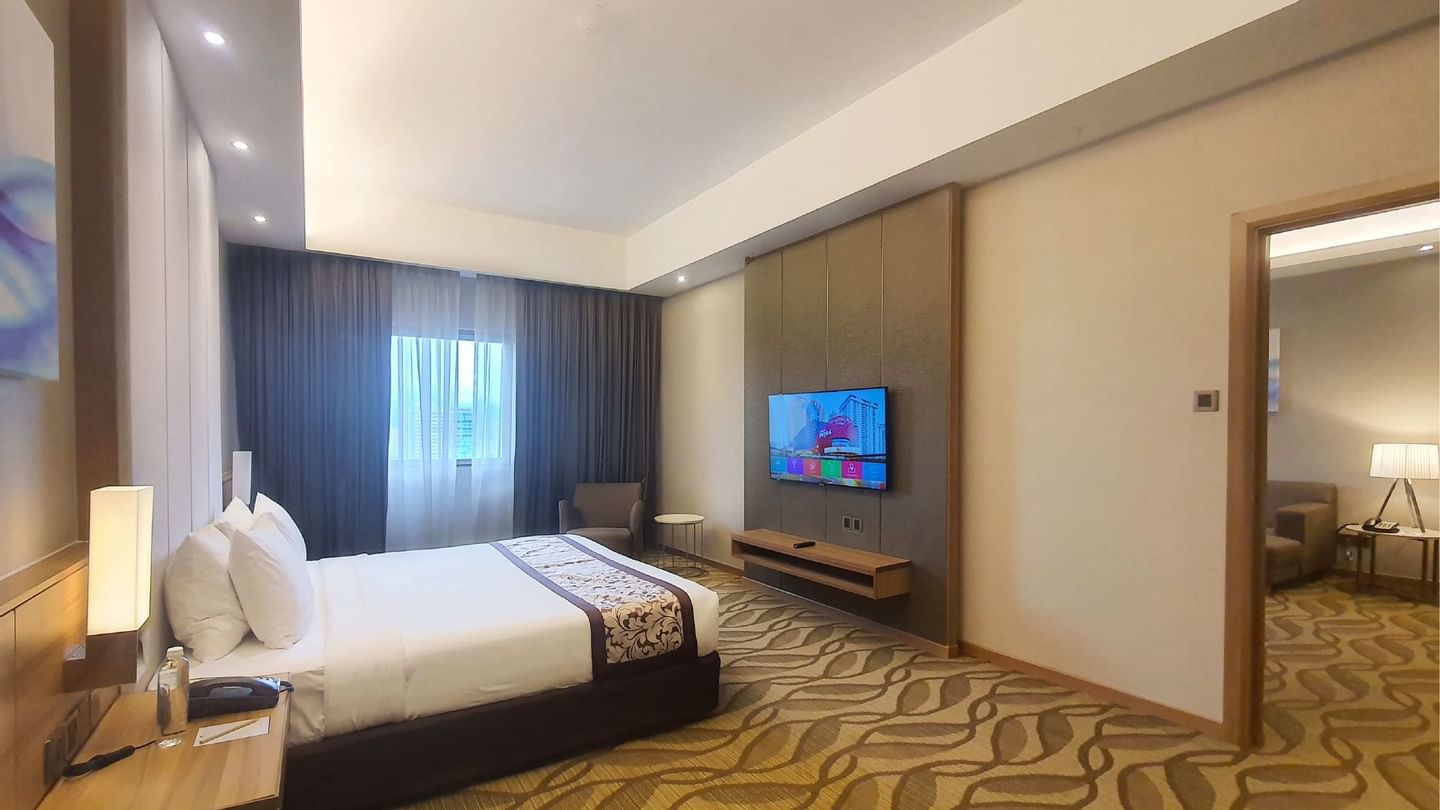 King-size bed with a single sofa in Suite at Sunway Hotel Seberang Jaya