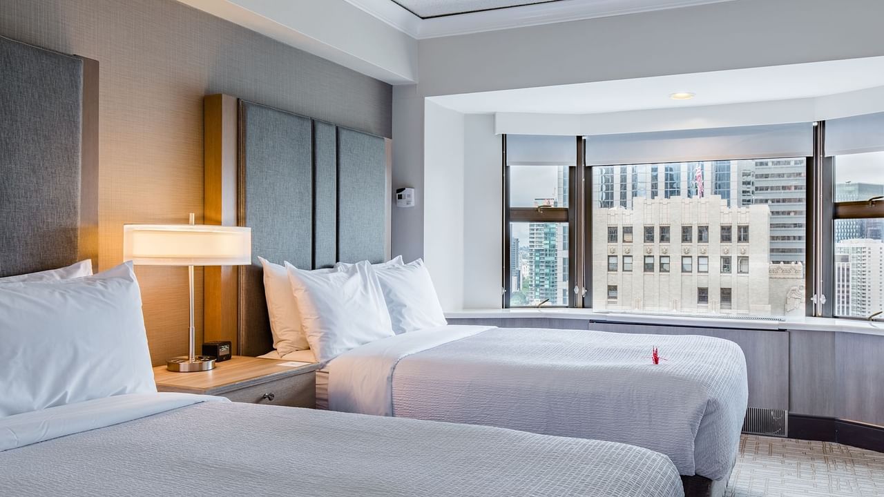 Hotel guestroom with two beds and a view of Seattle