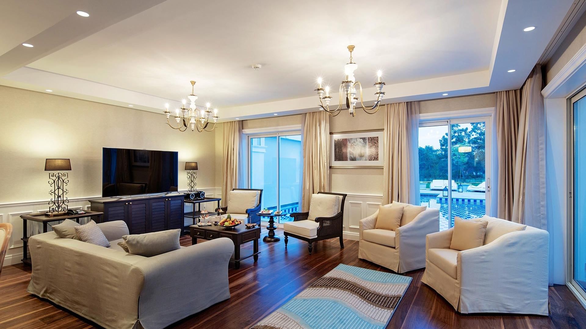 Вилла Superior в Titanic Deluxe Golf Belek — уютная зона отдыха с деревянным полом и телевизором.