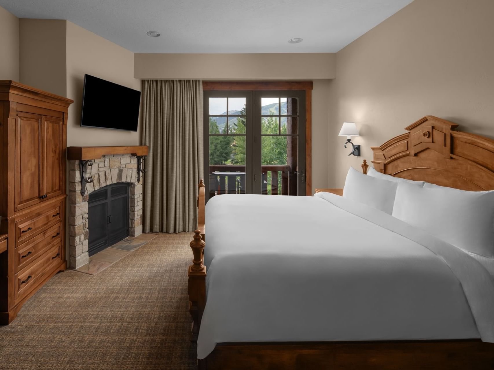 Grand Luxury Suite featuring cozy bed, fireplace, TV & wooden cupboard at Hotel Park City Autograph Collection
