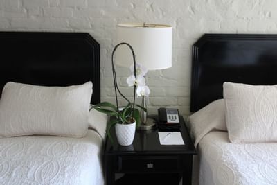 Guestroom with two beds & night table at La Galerie Hotel