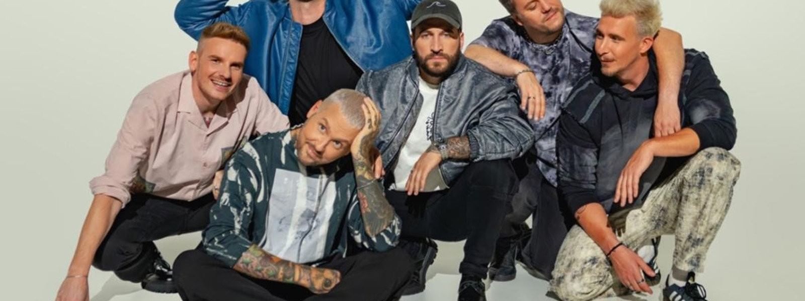 Six men in various poses and outfits promoting Electric Callboy's TANZNEID World Tour 2026.