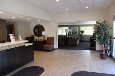 Bright, welcoming lobby at Moab Valley Inn with a reception desk, stylish decor, and a comfy lounge area with plants