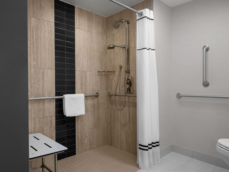 Boutique King Accessible bathroom with an accessible roll-in shower, grab bars, and a shower seat at Hotel 43 Boise
