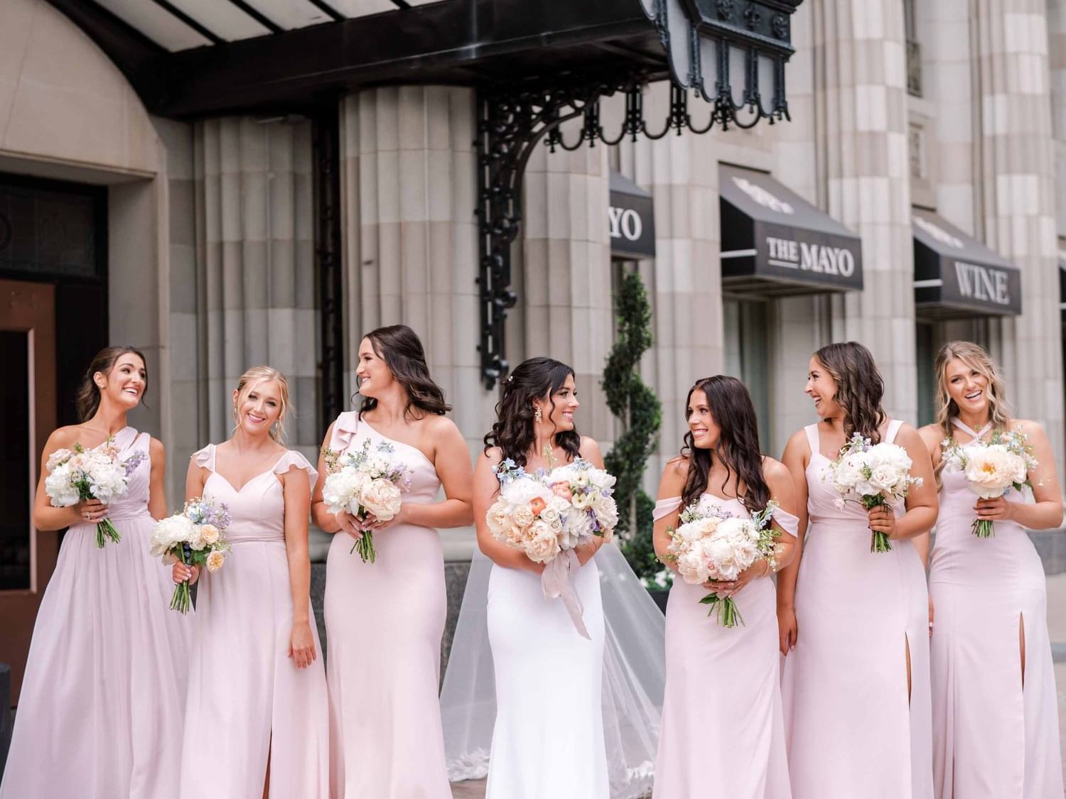 Bride with her wedding party posing outside The Mayo Hotel