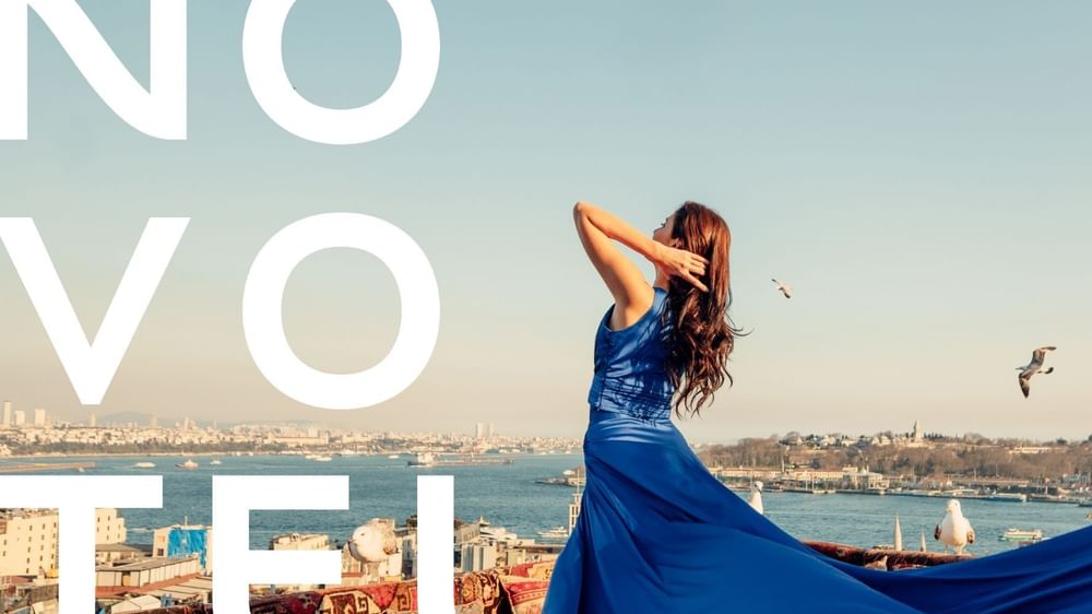 Woman in a long blue dress standing on a rooftop at Novotel Sydney Olympic Park