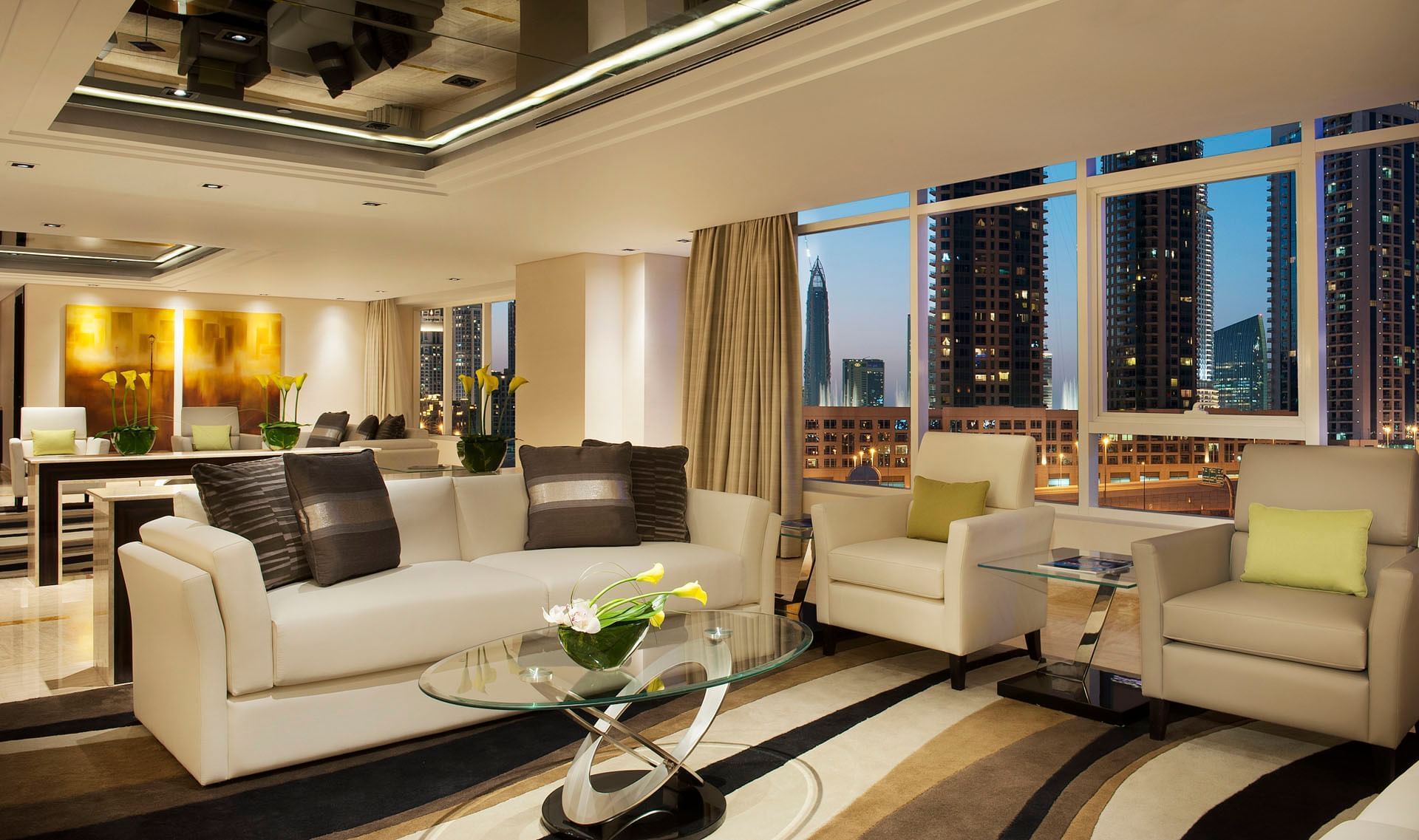 Lobby area with modern furniture, large windows, and city skyline view at DAMAC Maison Canal Views