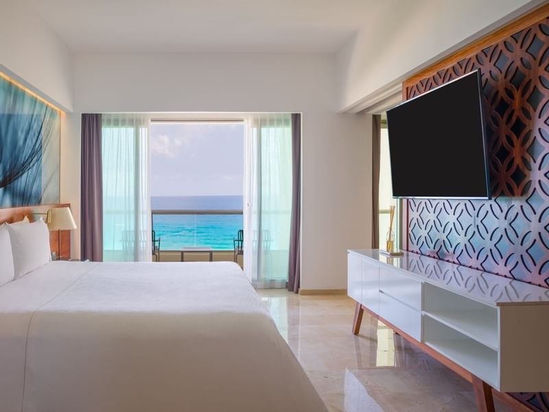 Viento Suite bedroom with king bed facing a TV and sea view at Live Aqua Beach Resort Cancun
