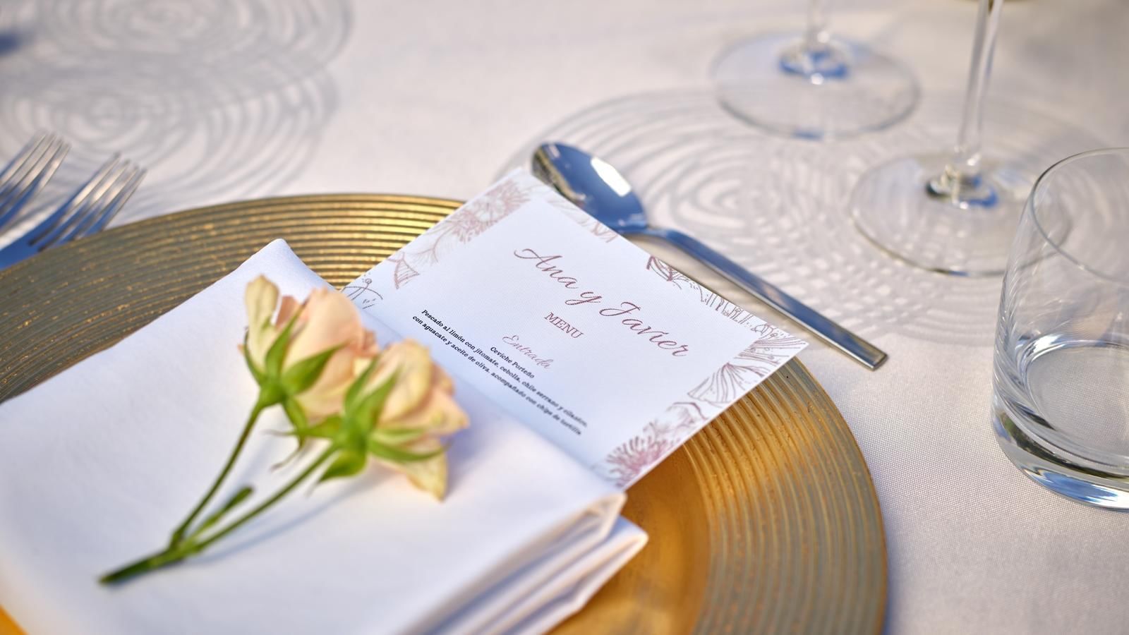 A wedding invitation & roses on a table at Live Aqua Resorts