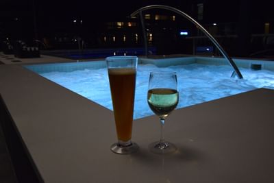 two drinks by a hot tub