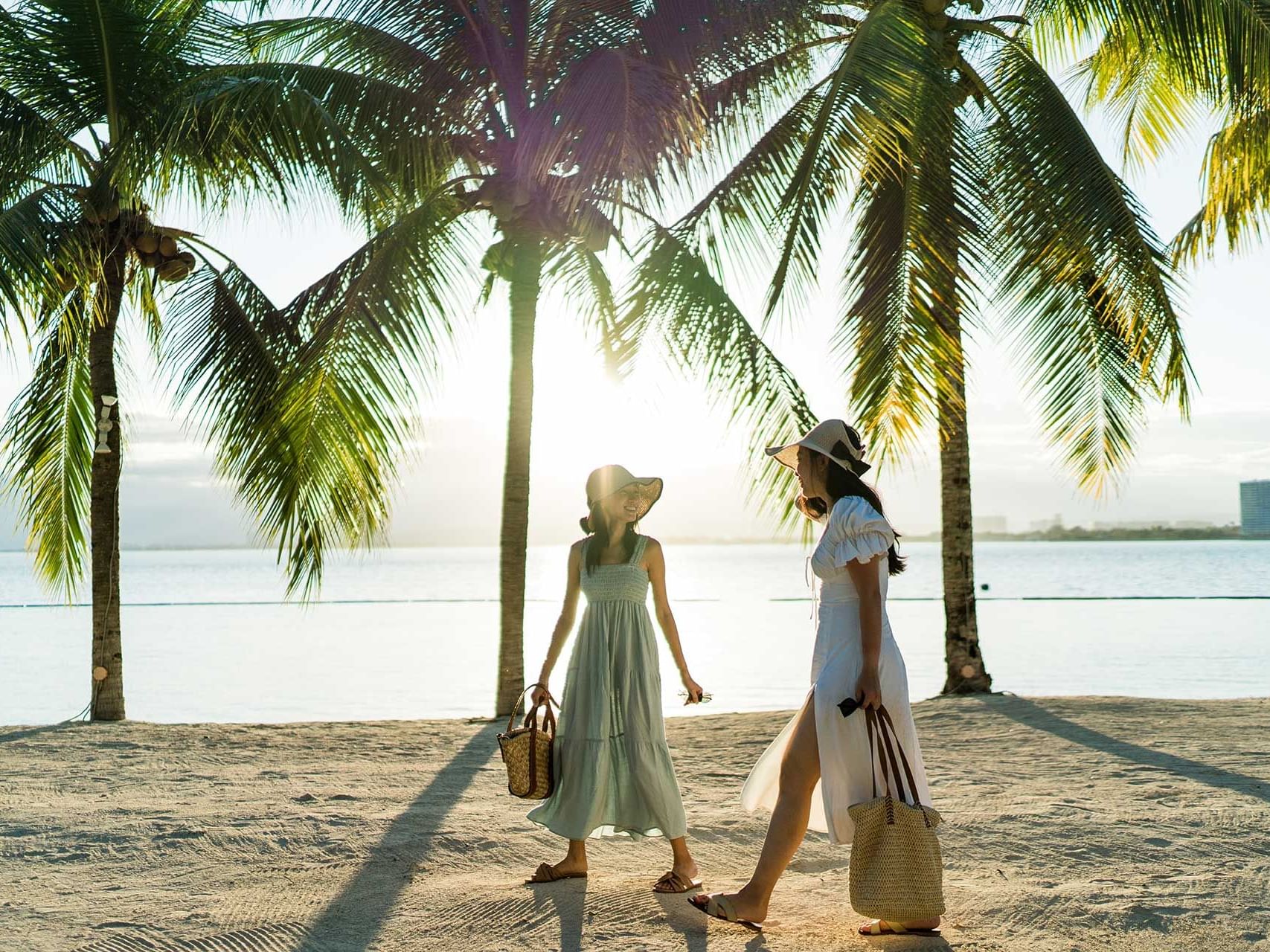 Two ladies walking on the Beach by palm trees, Discovery Samal