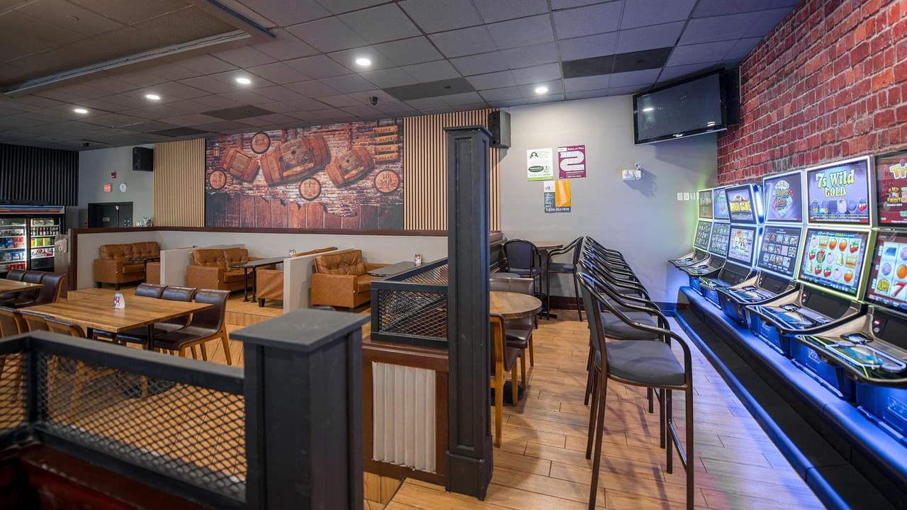 The Den lounge area with seating, bar, and slot machines.