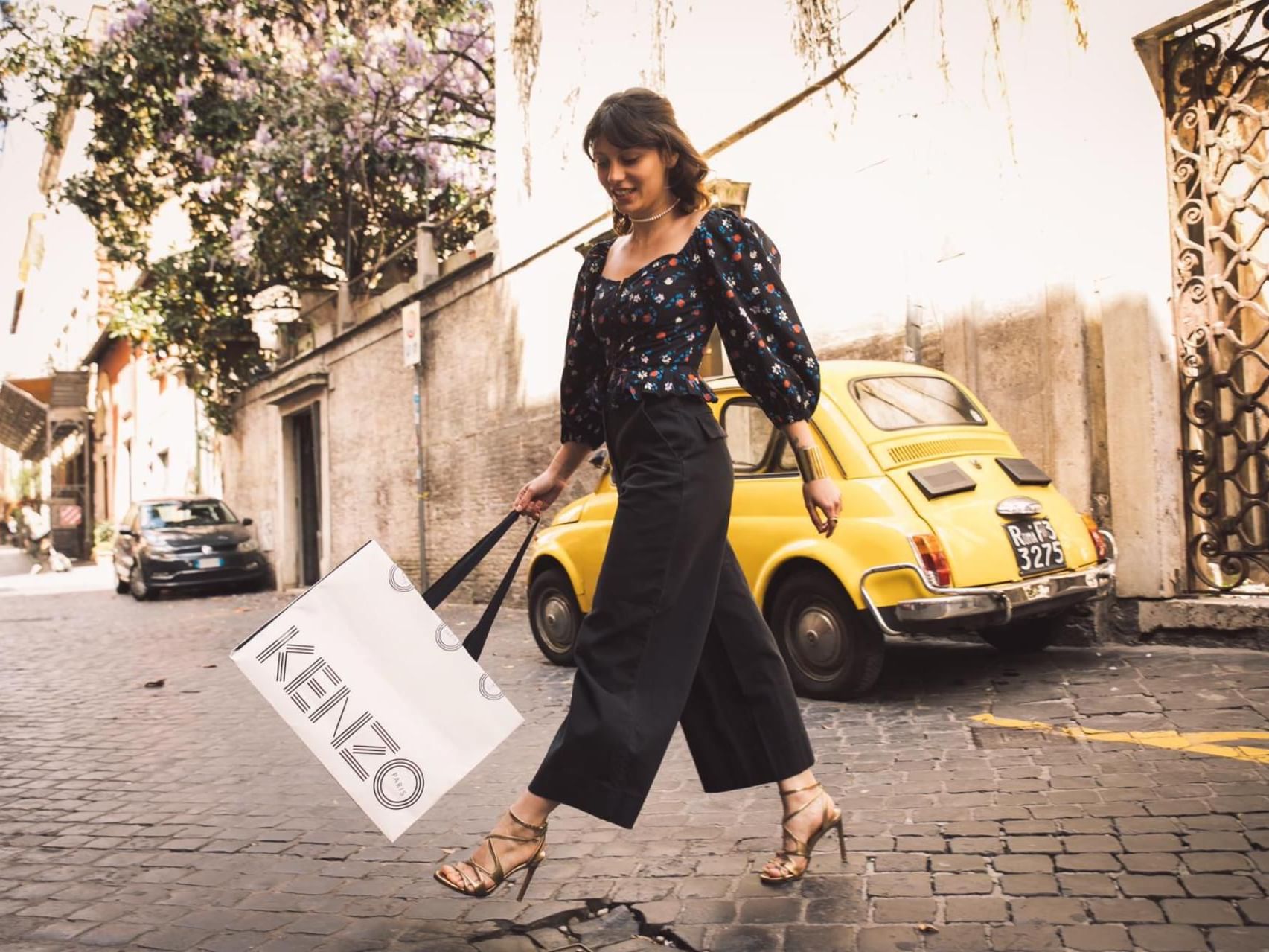 A woman with a shopping bag walking on Via Margutta near Rome Luxury Suites