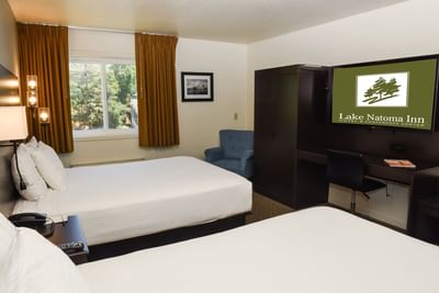Work desk with TV facing beds by the window in the Traditional Double Queen Room at Lake Natoma Inn