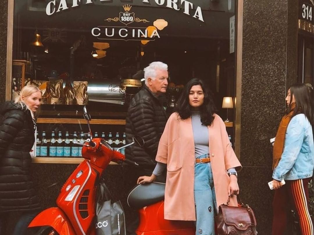 Girl leaning on bike in front of Caffe e Torta at Brady Hotels Central Melbourne