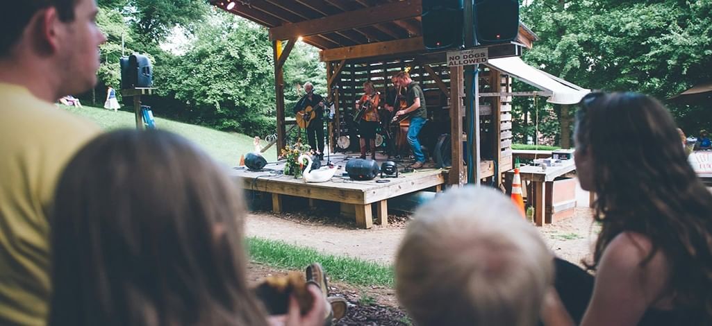 A family of four enjoys a picnic as they watch a live band in Canmore.