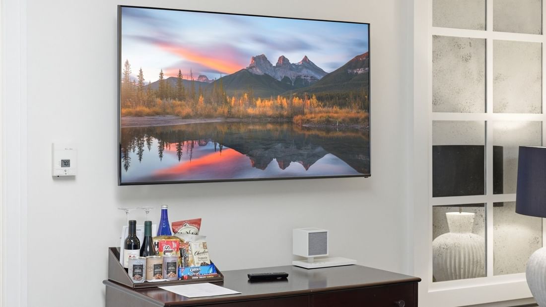 Grand Deluxe Suite with wall-mounted TV, dresser with snacks, and modern decor at el PRADO Hotel in Palo Alto