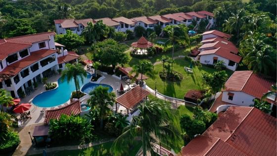 Aerial view of Sun Group Hotels with pool and red-roofed buildings surrounded by lush greenery
