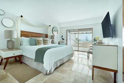Spacious and upscale hotel suite bedroom beautifully decorated with high-end contemporary furniture.