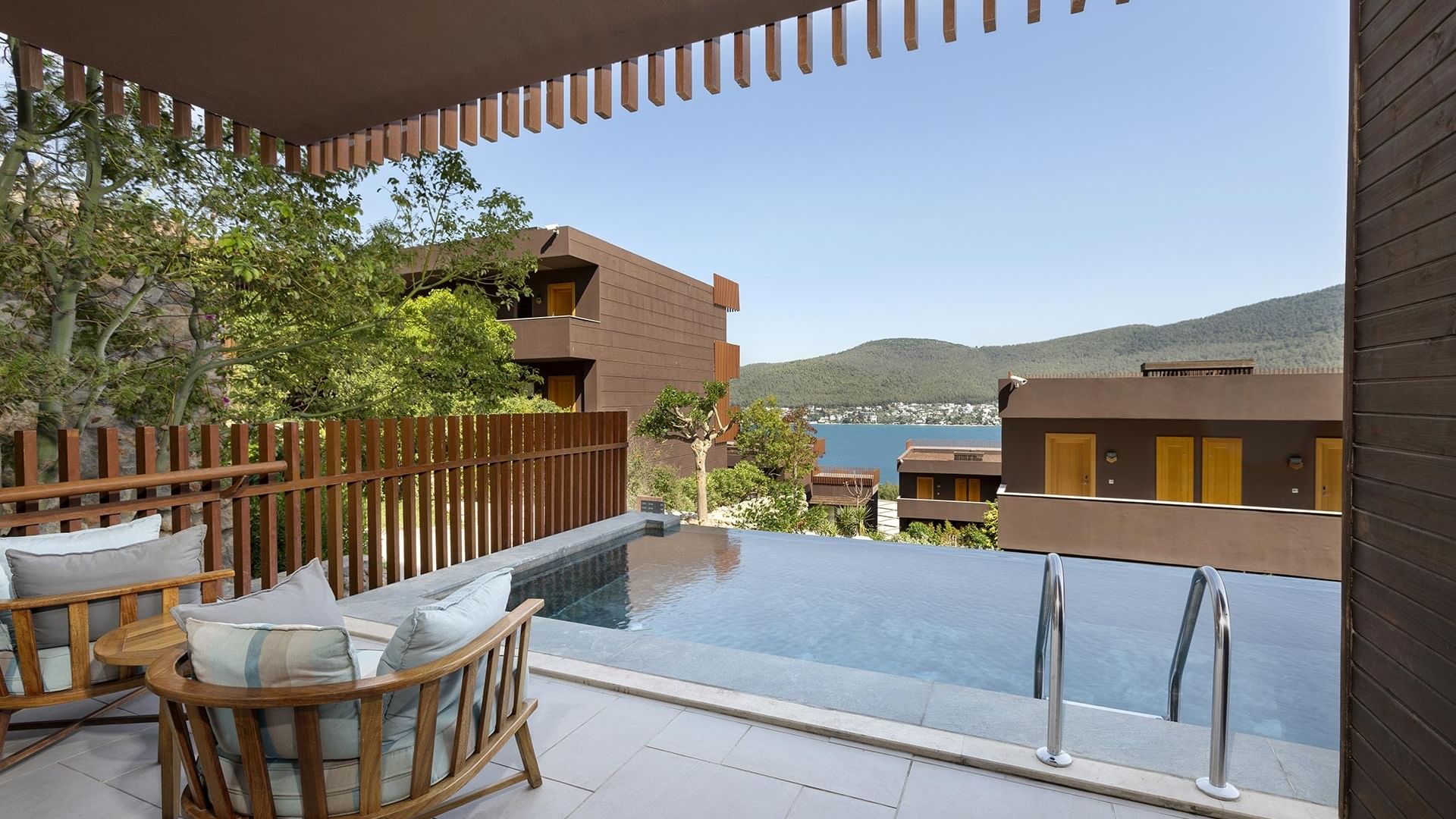 Lounge area by the outdoor pool in Swim-up Standard Room at Titanic Luxury Collection Bodrum.