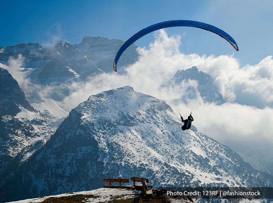 man paragliding with a breathtaking mountain view