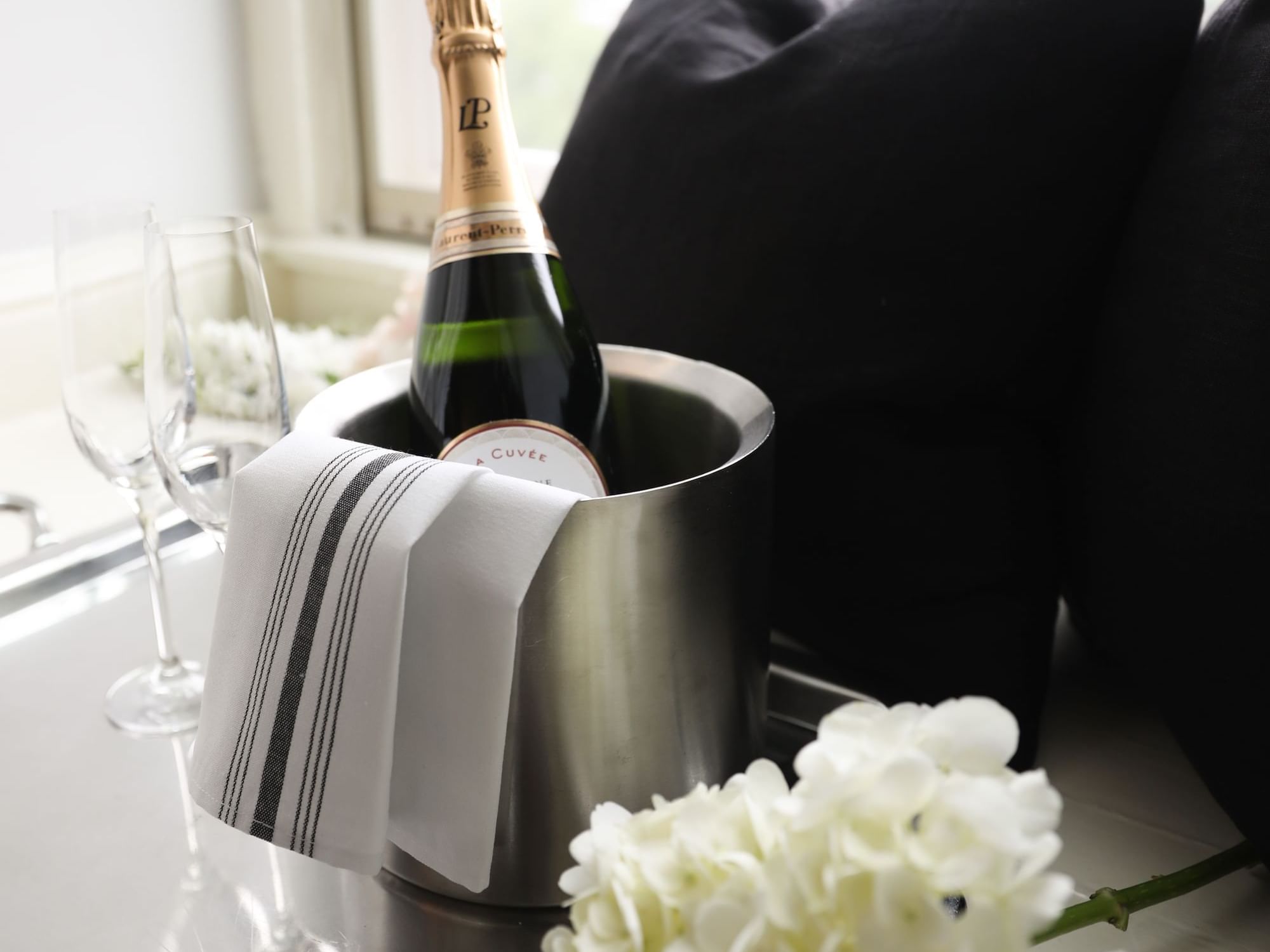 Champagne in an ice bucket with two glasses at The Eliot Hotel