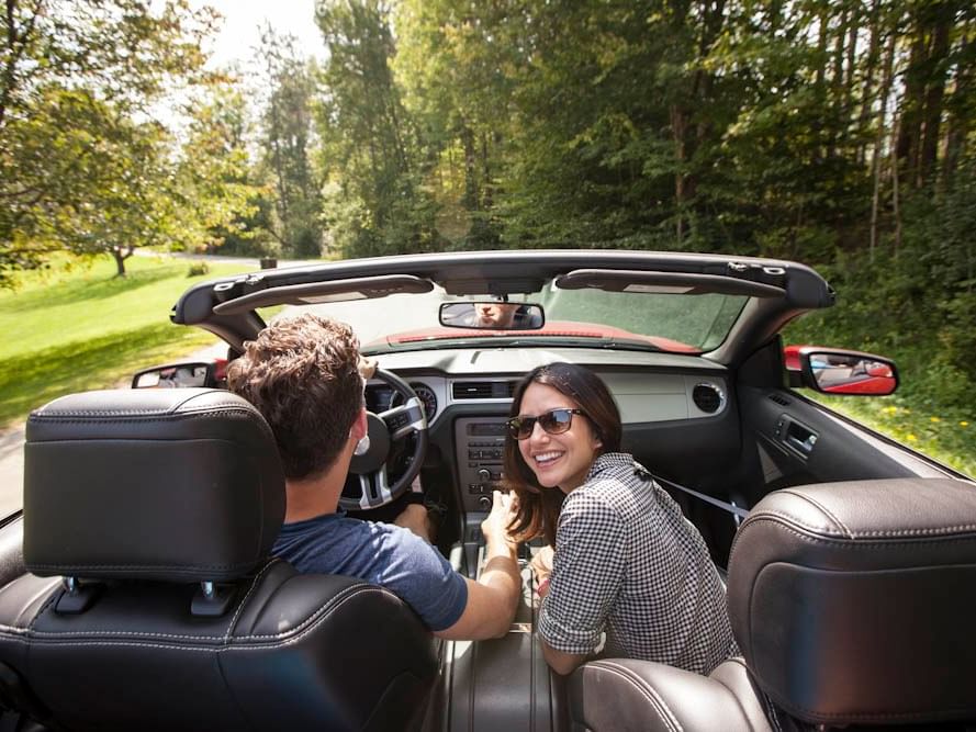 A couple driving a car around Topnotch Stowe Resort