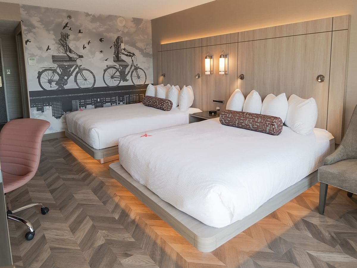 Hotel guestroom with two queen beds, work desk, and microwave