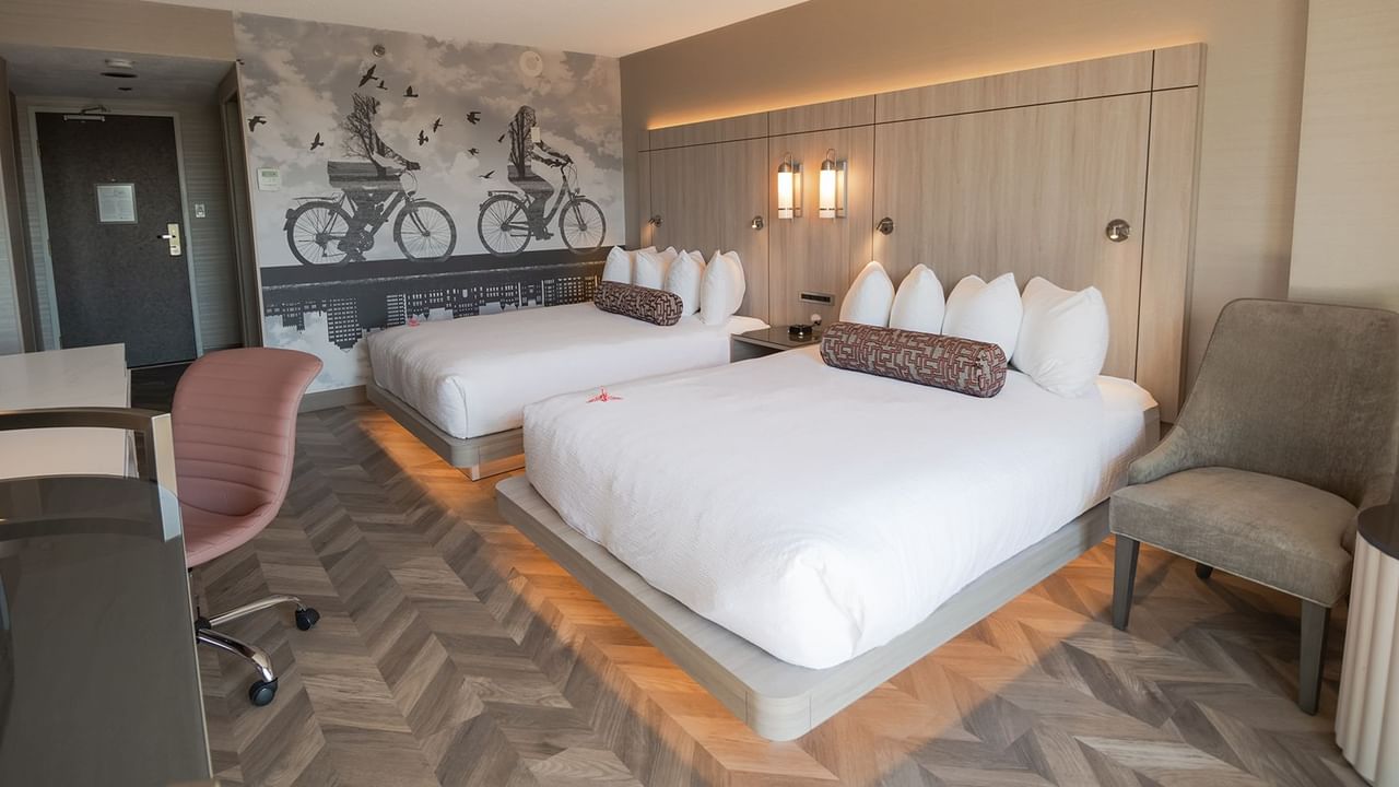 Hotel guestroom with two queen beds, work desk, and microwave