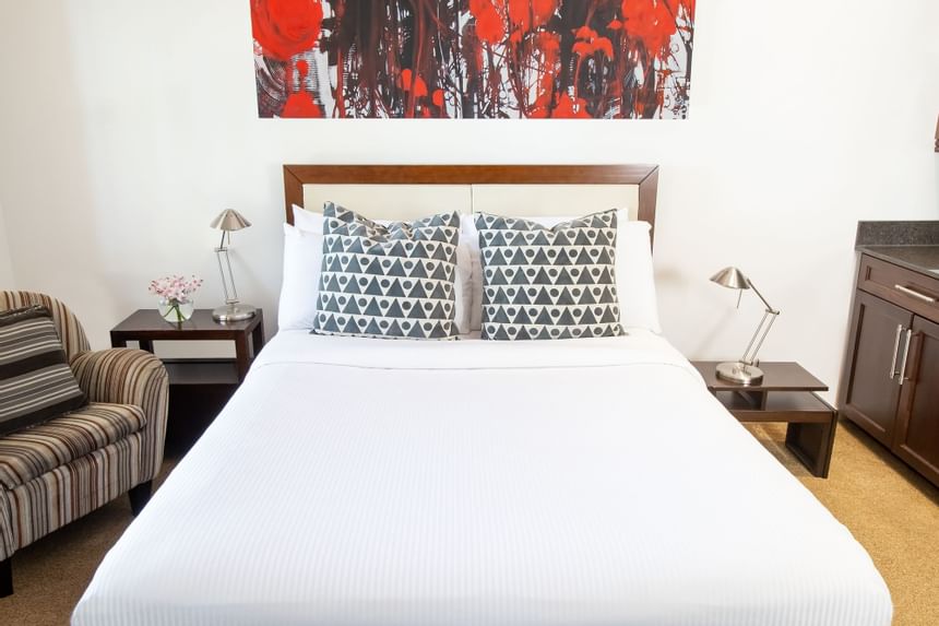 A comfy bed & bedside tables in Queen Premiere at Retro Suites