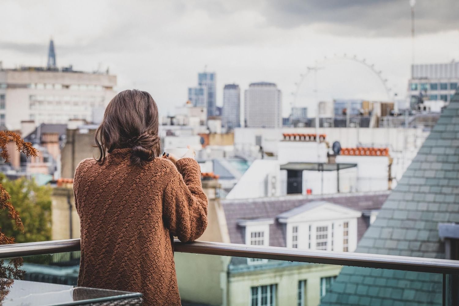 A Woman enjoying in the balcony at The May Fair Hotel London