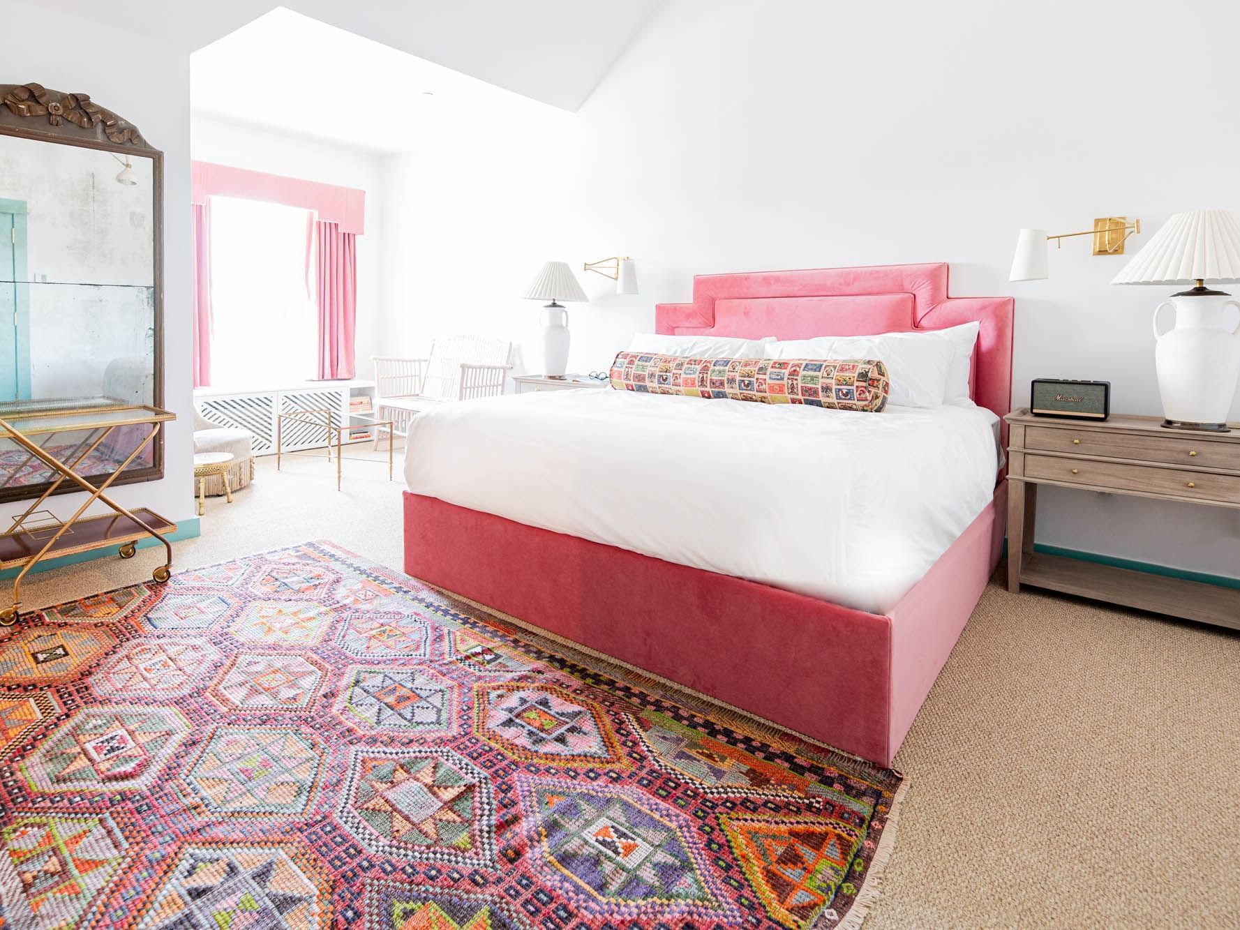 bed with pink headboard in white room