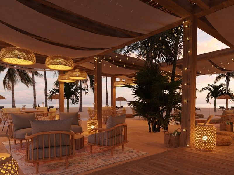 Salón relajante frente a la playa en Fiesta Americana Funeeq Punta Cana con sillones y lámparas de mimbre bajo sombra