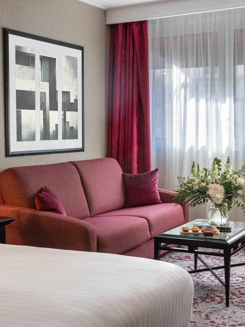 Chambre Executive avec grand lit, coin salon et fenêtre à l'hôtel Warwick Champs-Élysées à Paris.