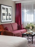 Chambre Executive avec grand lit, coin salon et fenêtre à l'hôtel Warwick Champs-Élysées à Paris.