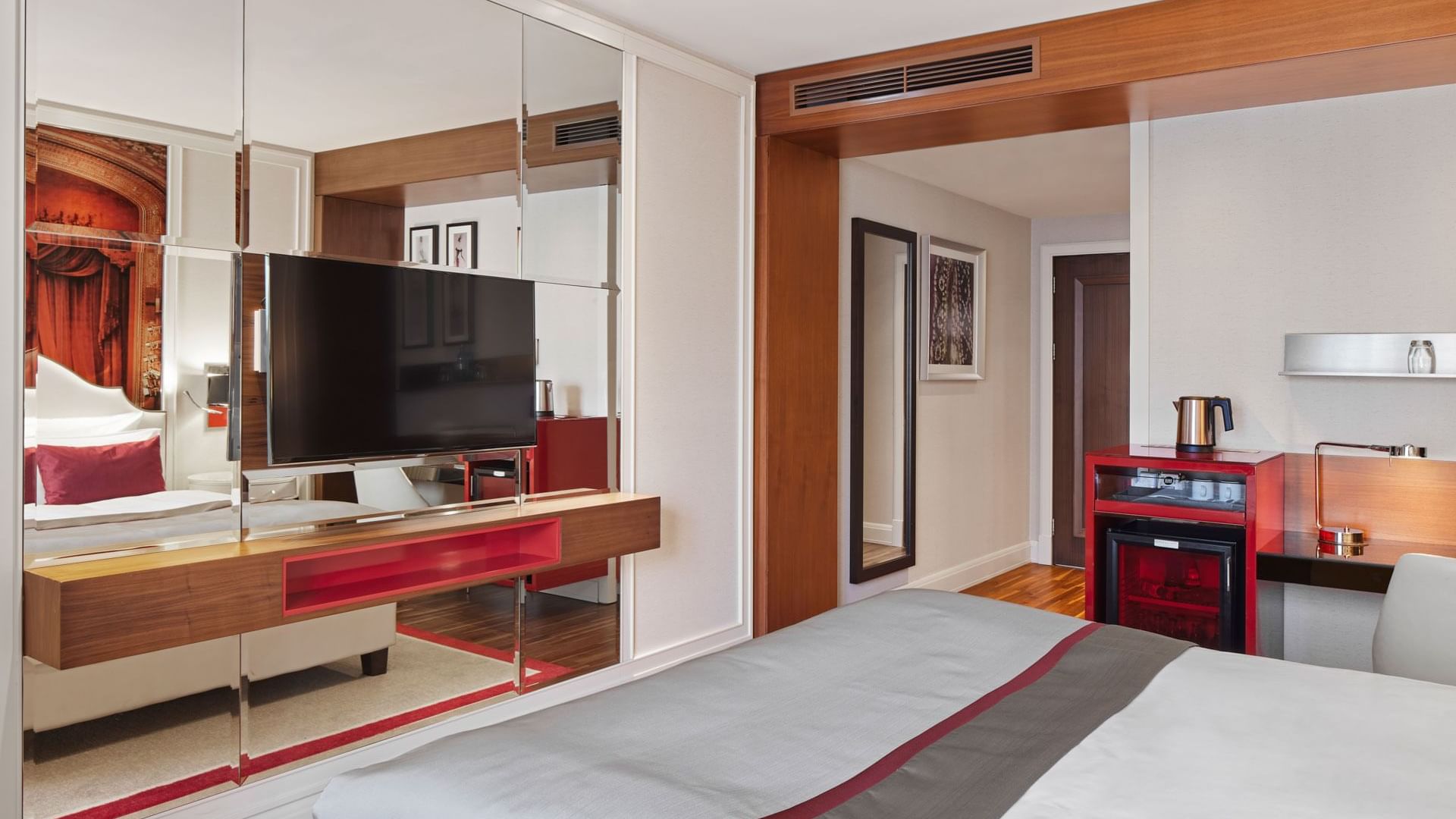 TV facing the cozy bed and tea corner in the Superior Room at Titanic Gendarmenmarkt Berlin