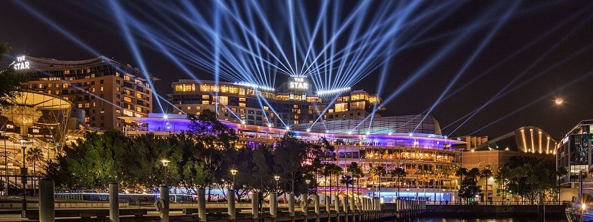 The Star Casino illuminated at night with dazzling light beams, near Novotel Sydney on Darling Harbour