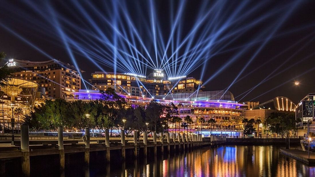 The Star Casino illuminated at night with dazzling light beams, near Novotel Sydney on Darling Harbour