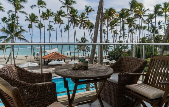 A balcony lounge area with pool & beach view at Club Hemingway
